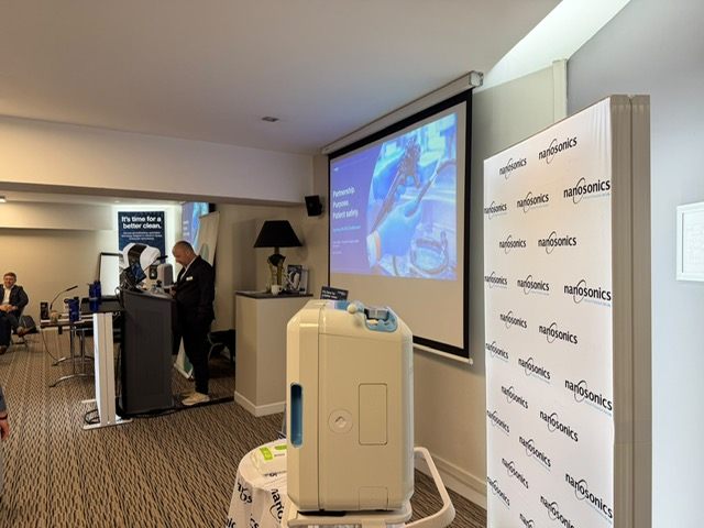 A speaker presenting beside a display stand.